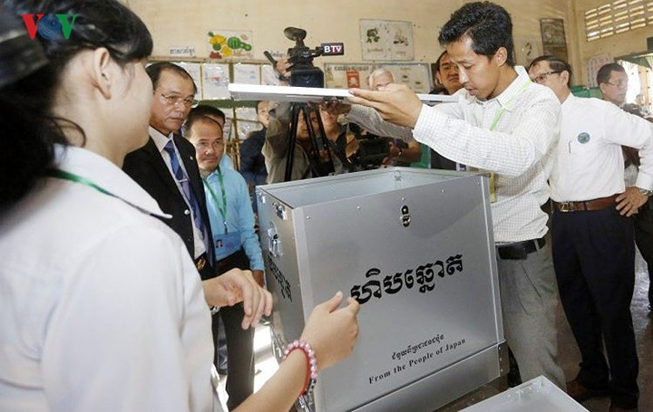 Các nhân viên kiểm tra thùng phiếu trước bầu cử.