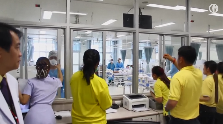 Người thân các cậu bé chỉ có thể nhìn các em qua lớp kính cách ly. Ảnh: The Guardian.