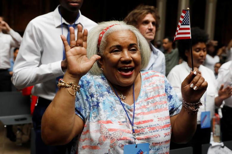 Công dân mới của nước Mỹ bà Angela Fabiola Rodriguez de Gonzalez đến từ Nam Mỹ mỉm cười trong buổi lễ nhập tịch. Người phụ nữ này là một trong nhiều người nhập cư may mắn được nhập quốc tịch Mỹ lần này khi các chính sách nhập cư của Mỹ ngày càng trở nên khó khăn hơn. Ảnh: Reuters.