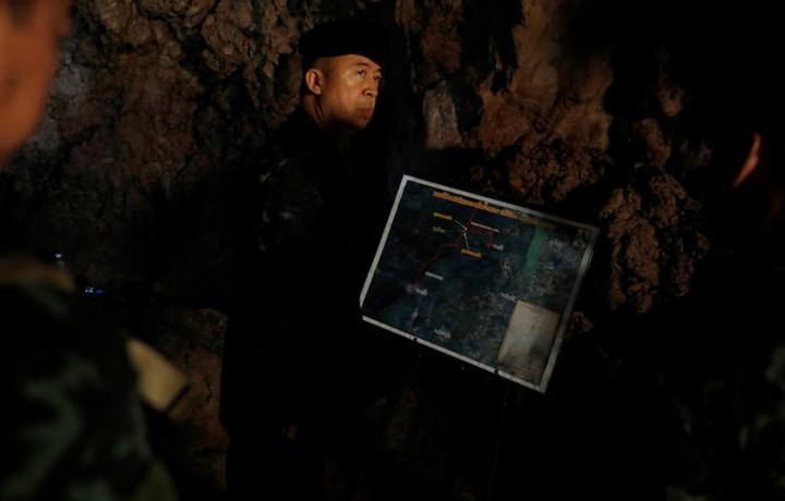 Chỉ huy lực lượng quân đội Thái Lan mang bản đồ hang Tham Luang để nghiên cứu các phương án cứu hộ. Ảnh: Reuters