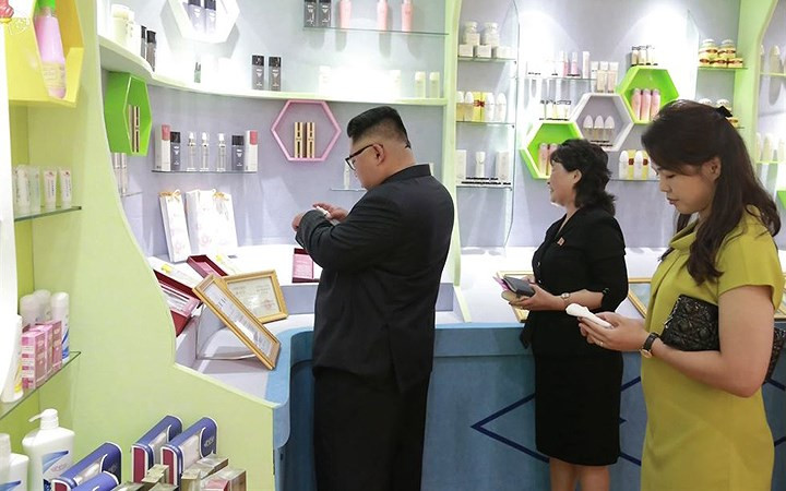 Ông Kim Jong-un thử mỹ phẩm của nhà máy sản xuất lên tay.