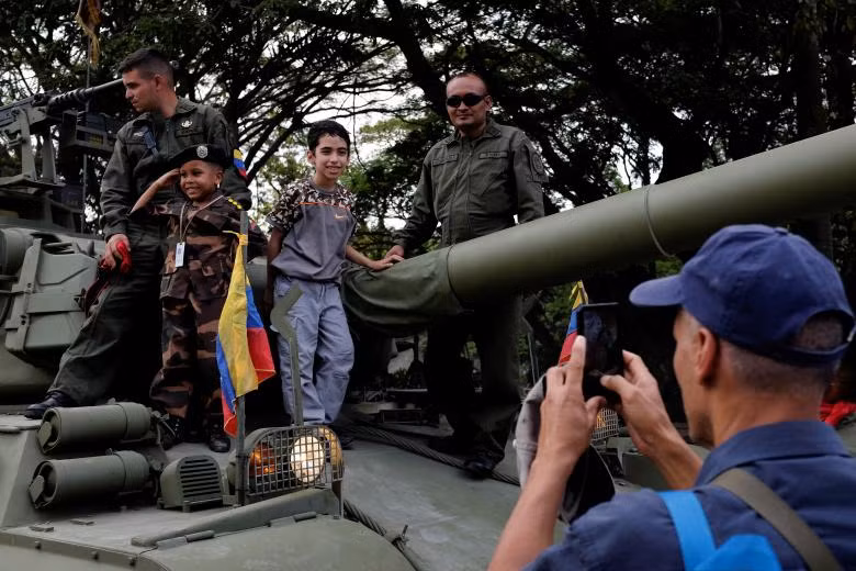 Các em nhỏ chụp ảnh cùng các binh sĩ trên một chiếc xe tăng quân sự.