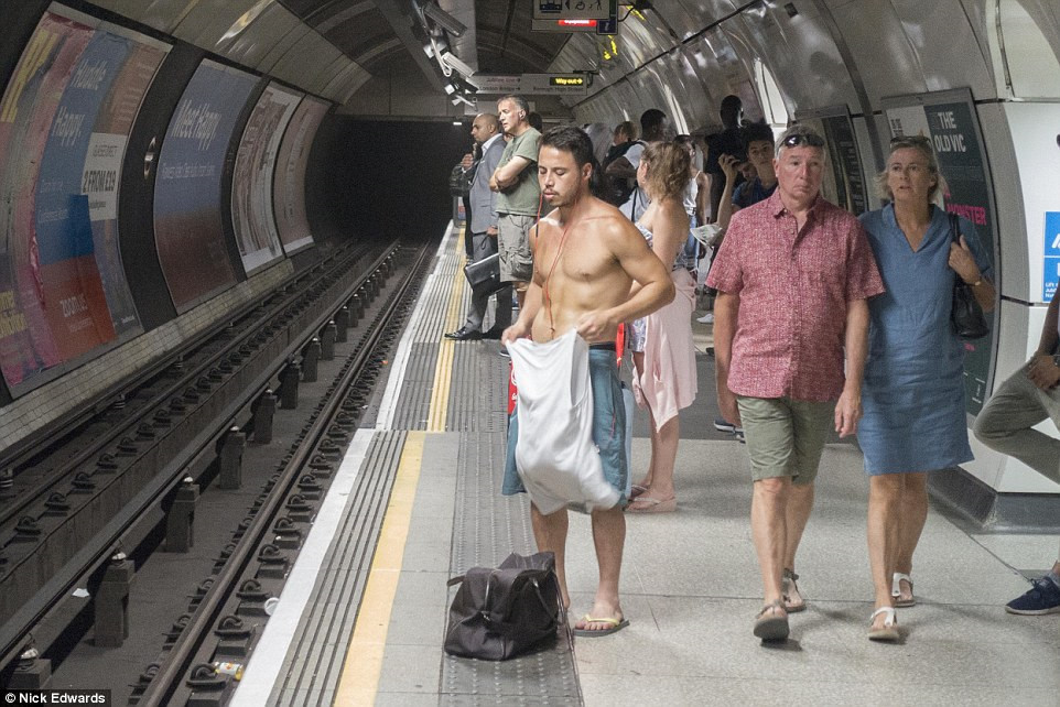 Tàu điện tại thủ đô London cũng nóng ngột ngạt. "Tôi không biết chuyện gì đang xảy ra nữa, thật kinh khủng", nhân viên ga tàu nói. Trong ảnh, một người đàn ông phải cởi áo để giảm nhiệt khi đợi tàu. Ảnh: Daily Mail