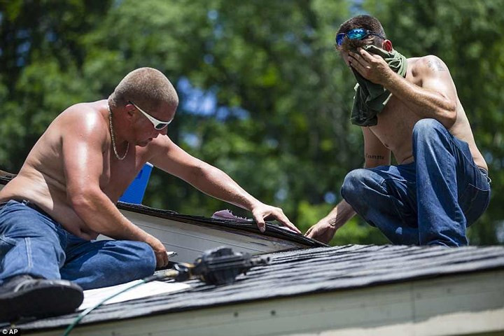 Nhưng cũng có nhiều người vẫn phải làm việc dưới nắng nóng như đổ lửa. Ảnh: AP