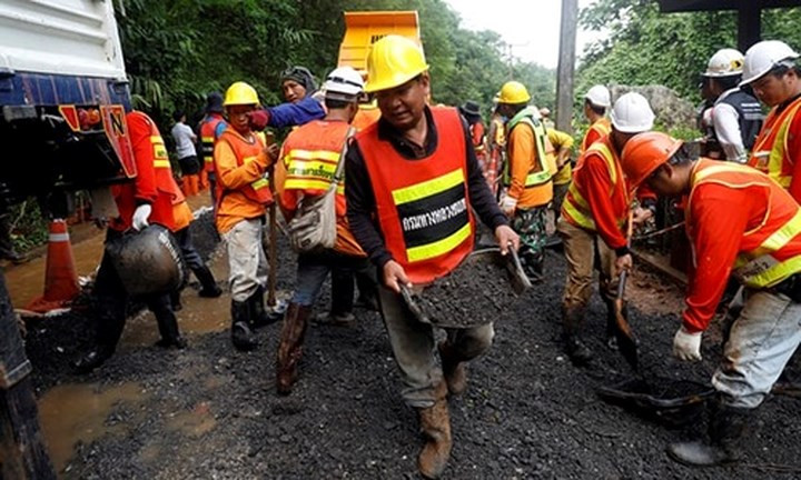 Các nhân viên cứu hộ di chuyển đất đá gần hang Tham Luang, nơi đội bóng nhí Thái Lan bị mắc kẹt. Ảnh: Reuters.