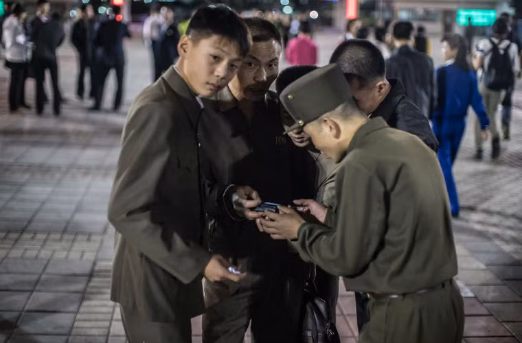 Những người lính Triều Tiên xem những bức ảnh được chụp bằng máy ảnh kĩ thuật số.