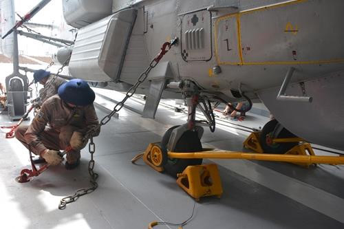 Các kỹ thuật viên cố định trực thăng vào sàn tàu. Tàu Quang Trung nói riêng và tàu hộ vệ tên lửa lớp Gepard 3.9 của Việt Nam không có nhà chứa cho trực thăng. Đuôi tàu chỉ có một góc nhỏ che được một phần 3 trực thăng.