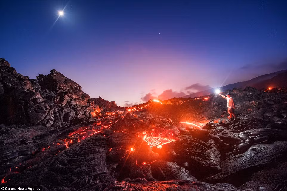 Nhiếp ảnh gia 32 tuổi đã mạo hiểm tự chụp anh đứng trên lớp dung nham chảy ra từ núi lửa Pumala Pali trong vườn quốc gia núi lửa ở Hawaii.