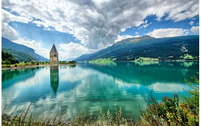  Curon Venosta, Trentino – Alto Adige: Thị trấn miền núi này bị san bằng vào năm 1950 để nhường chỗ cho một nhà máy thủy điện đòi hỏi sự hợp nhất của 2 hồ nước lớn. Tàn tích duy nhất còn sót lại của thị trấn từng một thời xinh đẹp này là tháp chuông của nhà thờ nhô ra trên mặt hồ nước và vào mua đông khi mặt nước đóng băng du khách có thể đi trên mặt hồ và lại gần tháp chuông. Có lẽ vẻ xinh đẹp chưa phai nhạt của thị trấn và hồ nước đóng băng chính là lý do kéo du khách đông đúc đổ về nơi đây.