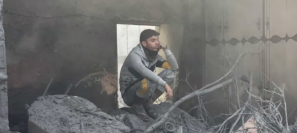 Người đàn ông ngồi giữa đống đổ nát ở Rafah, phía nam Dải Gaza, ngày 14/12.