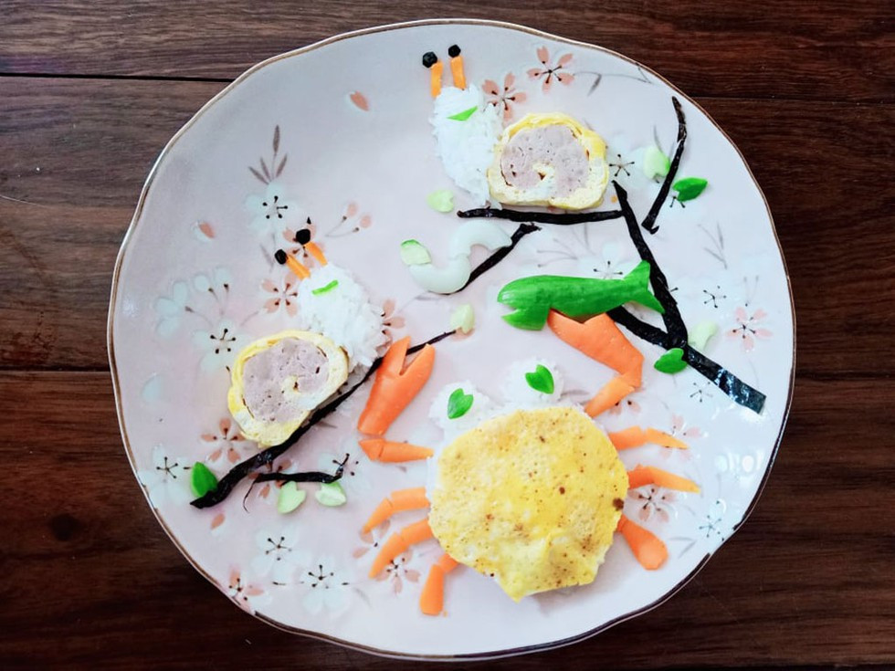 Đĩa cơm độc đáo như một bức trang với các món ăn được sắp xếp khéo léo.