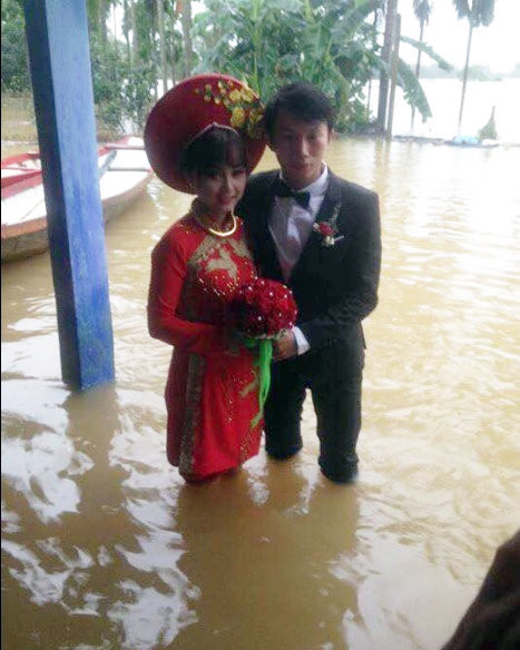 Hình ảnh cô dâu, chú rể xắn quần tươi cười chụp ảnh trong lễ ăn hỏi mùa lũ lụt.