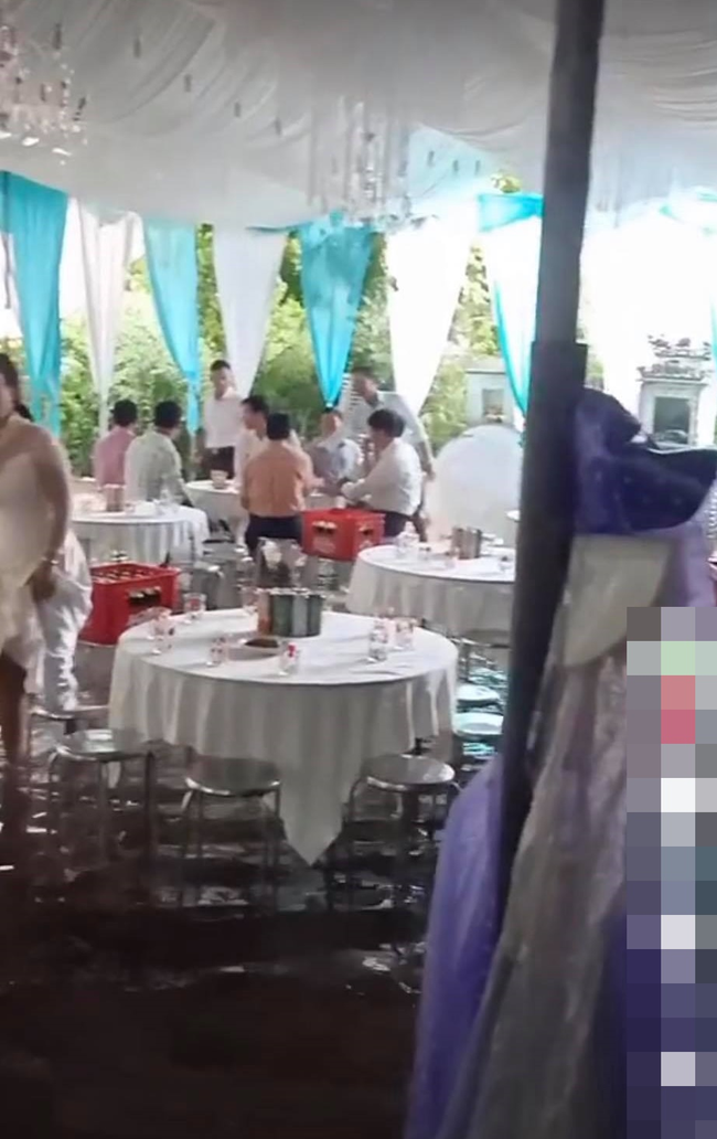 Mới đây, đoạn clip ghi xuất hiện trên MXH lại cảnh trong một đám cưới gây chú ý. Theo đó, nước lũ lên ngập ngang bắp chân người, phía trên vẫn là các bàn tiệc.