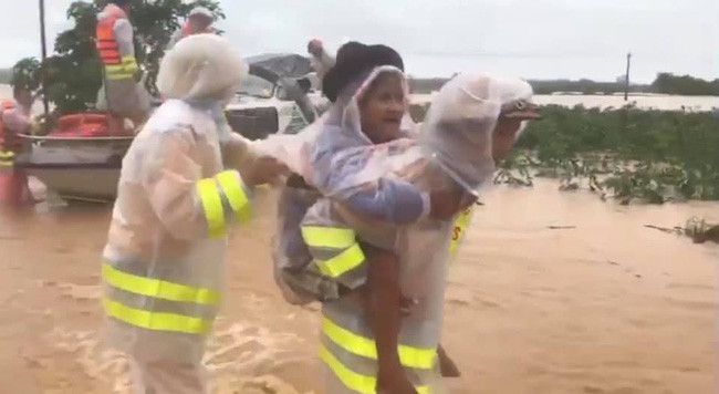 Người già được lực lượng chức năng giải cứu khỏi vùng bị cô lập do lũ lụt tại miền Trung.