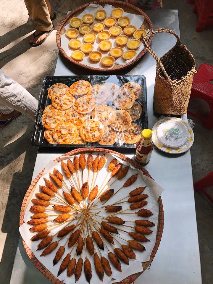 Bà mẹ 8X tự tin khoe đồ ăn do tự tay chị chuẩn bị cho lớp của con trai tổ chức hội chợ ở trường, gồm có nem lụi được chế biến theo khẩu vị của các bé, pizza nhỏ, bánh tart trứng. "Một mình làm rất mệt vì phải tự tay đi lựa chọn thực phẩm, thức đến 2h đêm, sáng 5h dậy quạt và nướng, cuối cùng cũng xong cảm thấy rất vui, đúng có thể làm bất cứ thứ gì vì các con hết mà không quản ngại", bà mẹ trẻ chia sẻ trong hạnh phúc.