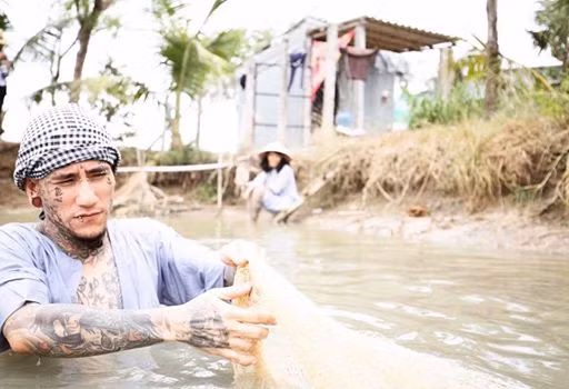 "Anh nông dân xăm trổ" xắn tay đi bắt cá. "Hi vọng mẻ cá này trúng lớn, cho anh có tiền sắm vàng cưới em", Phạm Mai bình luận vui về bức ảnh của hai người.