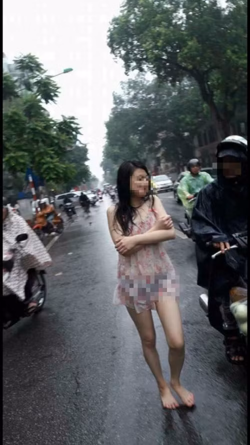 Trong khi nhiều người phải mặc áo mưa hay tìm chỗ trú mưa thì cô gái này lại đầu trần, đi chân đất và diện chiếc váy mỏng tang đi giữa đường khiến nhiều người cảm thấy khó hiểu. Ảnh: FB Nguyen Nguyen.