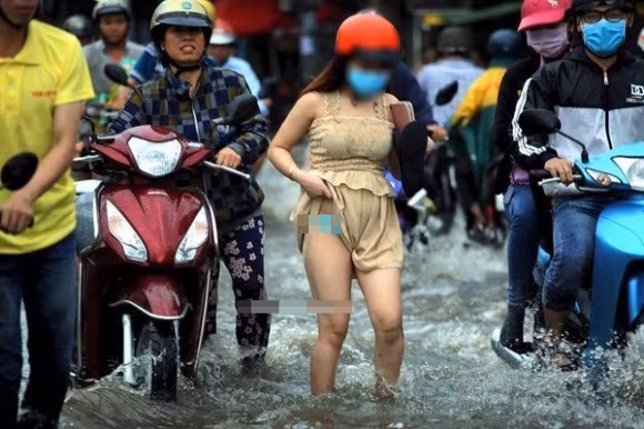 Trong khi mọi người đang mải chống đỡ với tuyến đường bị ngập lụt để nhanh chóng về được đến nhà, thì cô gái trẻ mặc "mát mẻ" lại có cách xử lý tình huống không giống ai khiến nhiều người phải bật cười. Bức ảnh được lan truyền trên mạng sau trận mưa lớn ở Sài Gòn hôm 15/5 vừa qua cho thấy để tránh bị ướt, cô gái này đã vén váy lên quá cao, làm lộ cả nội y.