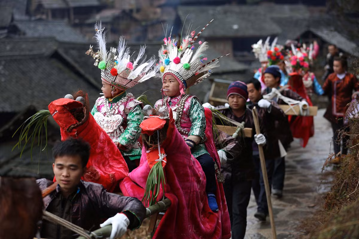 Trẻ em tộc người Đồng chơi trong dịp Taiguanren, một lễ hội truyền thống ở đó các em nhỏ hay khách được dân làng rước kiệu quanh làng.