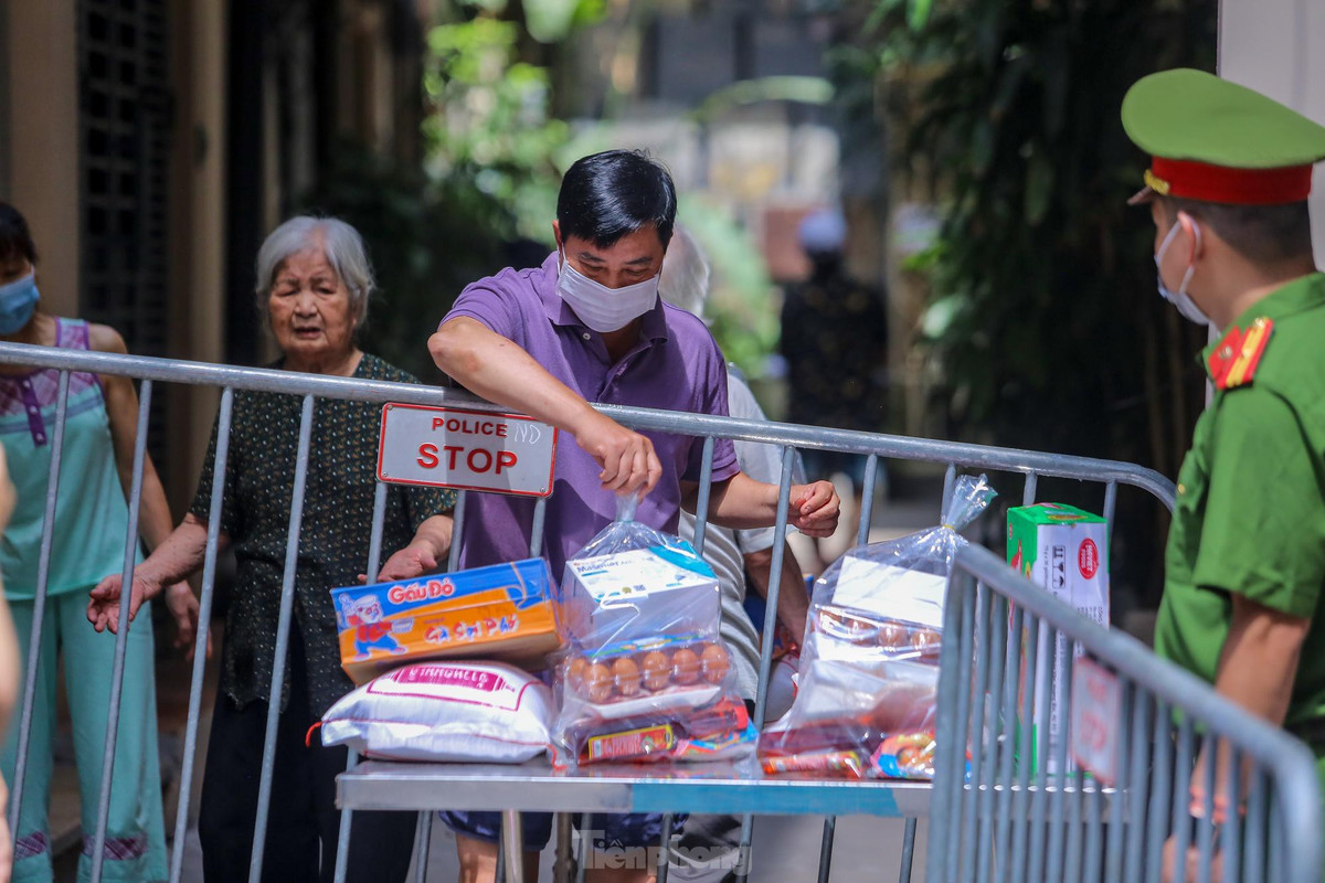 Người dân nhận đồ tiếp tế từ chiếc bàn được đặt sẵn. 