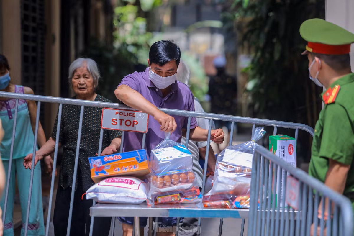 Người dân nhận đồ tiếp tế từ chiếc bàn được đặt sẵn. 
