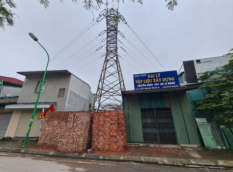 Một điểm tập kết vật liệu xây dựng khác ngang nhiên quây kín chân cột điện cao thế.