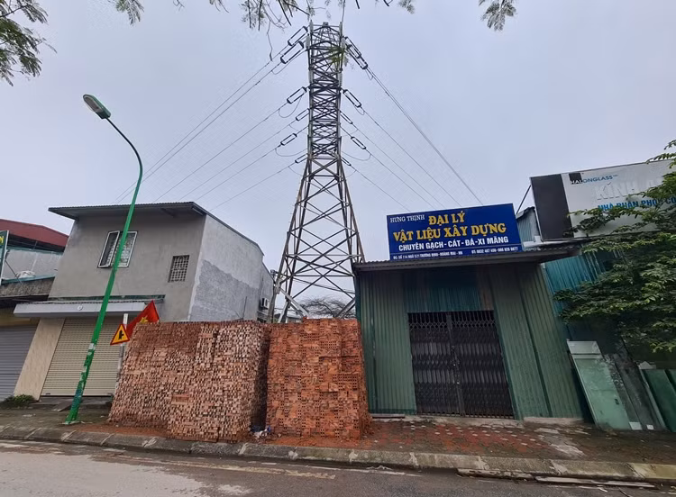 Một điểm tập kết vật liệu xây dựng khác ngang nhiên quây kín chân cột điện cao thế.