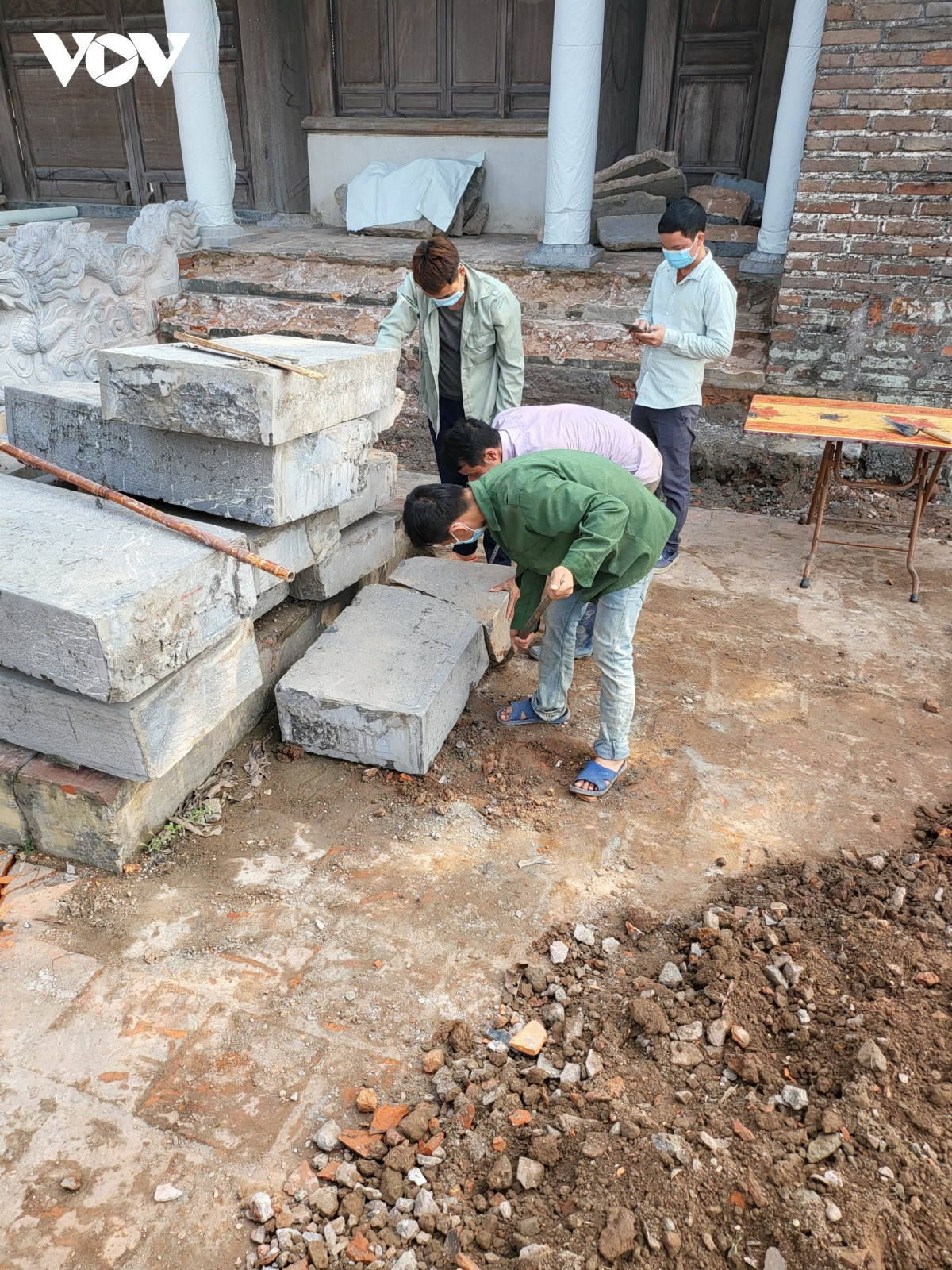 Những bậc đá cũ xếp ngổn ngang trước cổng đình.