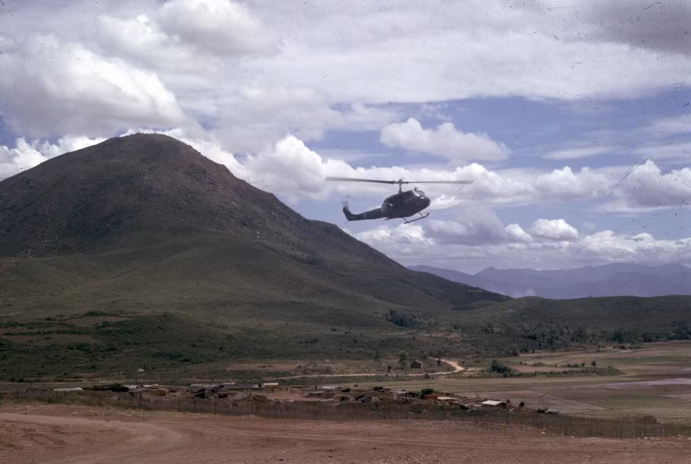 Chiếc trực thăng bay qua một ngôi làng nhỏ dưới chân núi Chóp Chài.