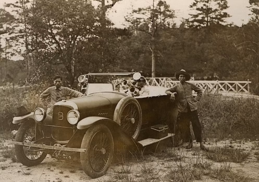 Thanh niên địa phương tạo dáng bên chiếc xe hơi của người Pháp.