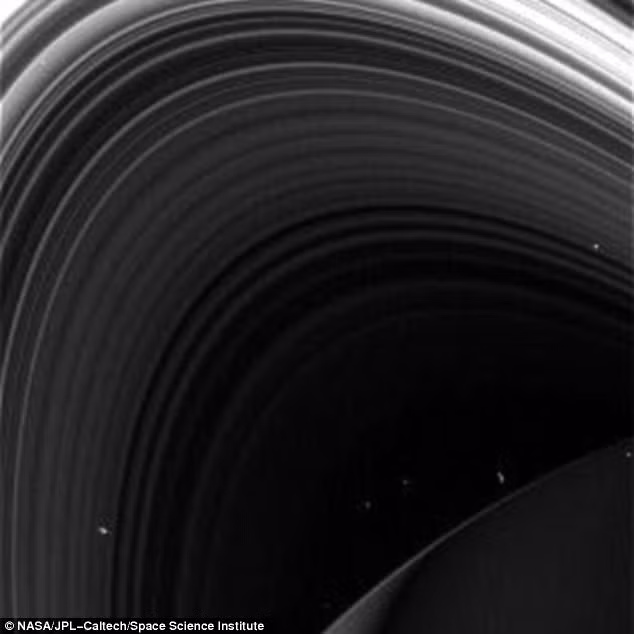 Và cuối cùng là bức ảnh cận cảnh mô tả một phần sao Thổ với vòng nhẫn được phóng to, lấp ló các đốm trắng mờ là các mặt trăng vệ tinh, tiểu hành tinh tồn tại trong hệ thống sao Thổ. Nguồn ảnh: Dailymail.