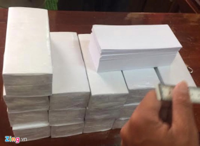 17 cọc giấy trắng mà các nghi phạm lừa nạn nhân được cảnh sát thu giữ. Ảnh: M.A.