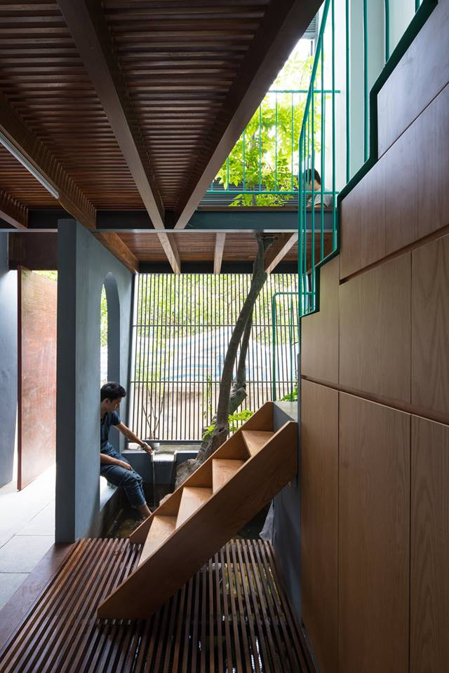 Cầu thang xi măng với lan can sắt sơn màu xanh ngọc bắt mắt.