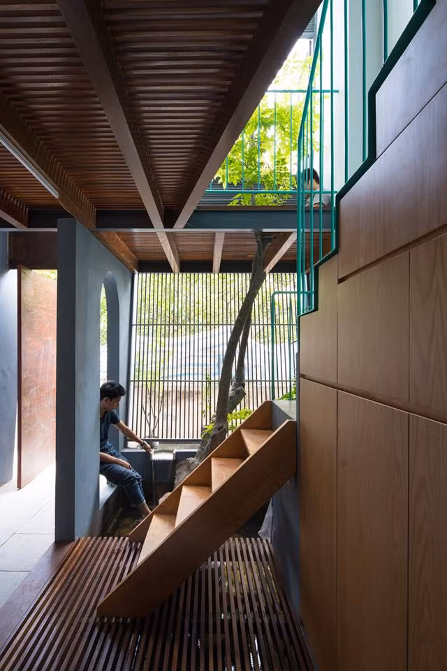 Cầu thang xi măng với lan can sắt sơn màu xanh ngọc bắt mắt.