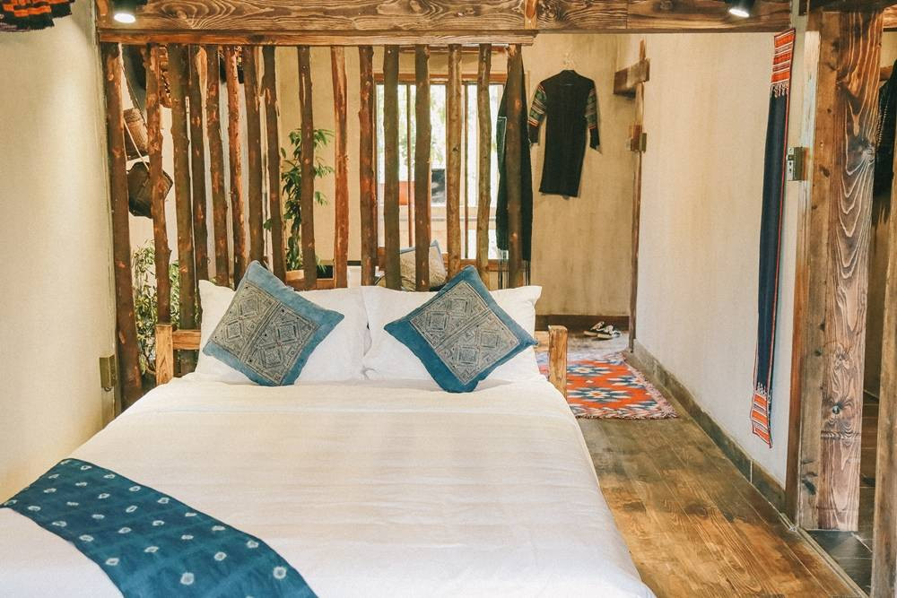 Cạnh phòng khách là không gian phòng ngủ với vách gỗ thô mộc.