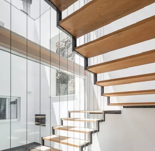 Cầu thang gỗ được nâng đỡ bằng khung thép phù hợp với vị trí không có tường bên cạnh. Ảnh: FPA.