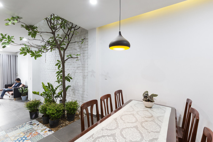 Sân vườn nhỏ được thiết kế giật cấp ngăn cách phòng khách với bếp, bàn ăn.