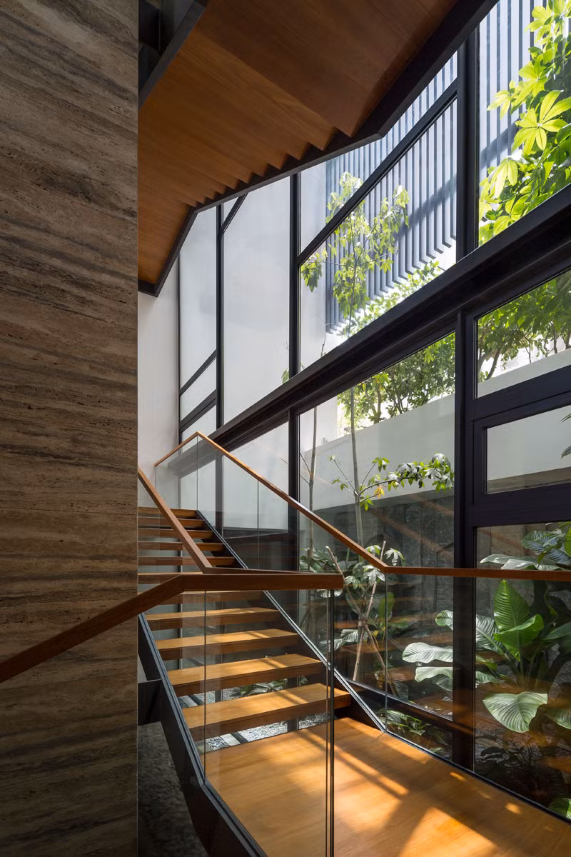 Cầu thang gỗ khung thép, lan can kính hiện đại.