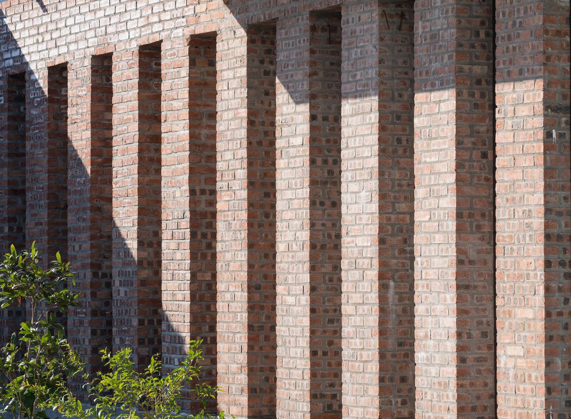 Những trụ cột vuông vức bằng gạch mộc tạo nên sự tương phản mạnh mẽ với vật liệu hiện đại.