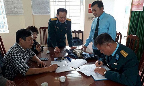 Đại diện Quân chủng Phòng không không quân ký biên bản bàn giao mảnh vỡ máy bay do TS Nguyễn Lê Anh chuyển tới. Ảnh: TUYẾN PHAN