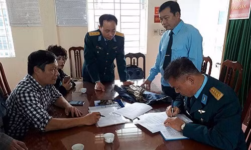 Đại diện Quân chủng Phòng không không quân ký biên bản bàn giao mảnh vỡ máy bay do TS Nguyễn Lê Anh chuyển tới. Ảnh: TUYẾN PHAN