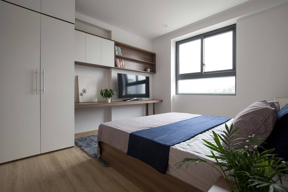 Nhờ sự hiện diện của sàn gỗ, chậu cảnh xanh tốt nơi bàn đầu giường giúp căn phòng trông gần gũi với thiên nhiên hơn.