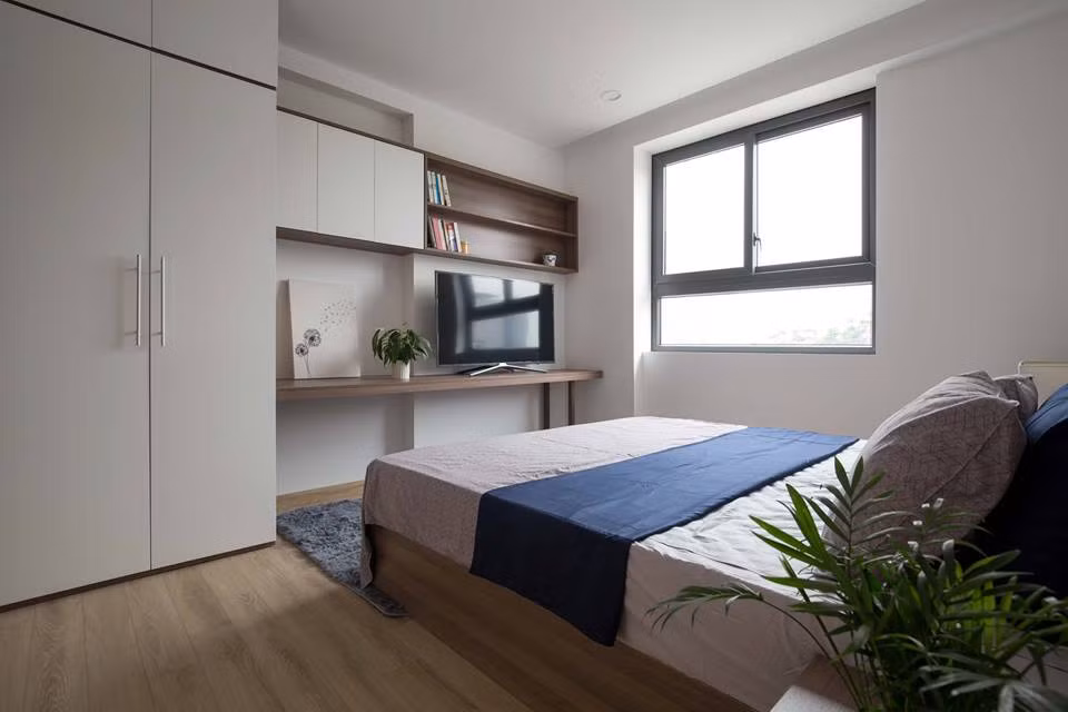 Nhờ sự hiện diện của sàn gỗ, chậu cảnh xanh tốt nơi bàn đầu giường giúp căn phòng trông gần gũi với thiên nhiên hơn.