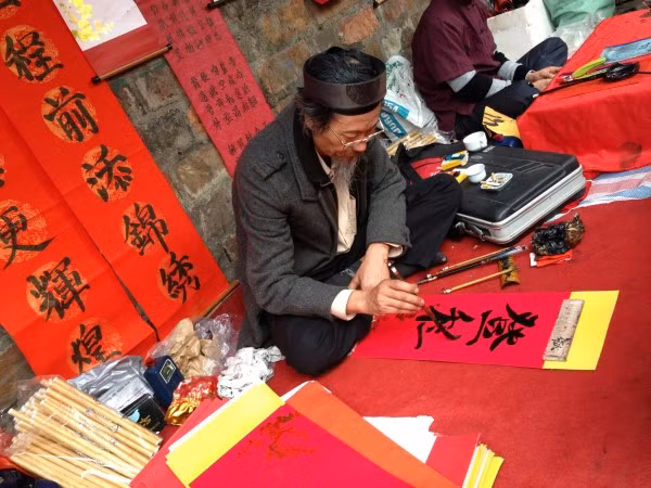 Xin chữ đầu năm cũng là ước vọng cầu may mắn, phúc đức cho cả gia đình. Ảnh: Baohaiquan.