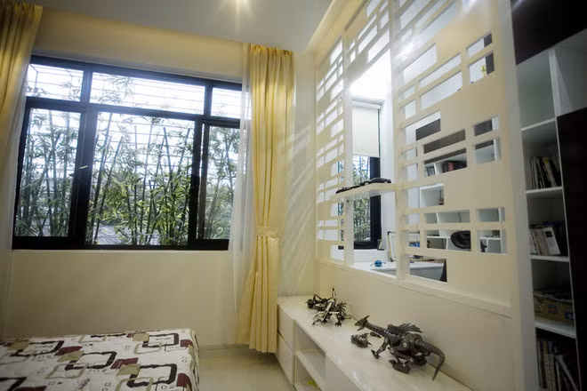 Phòng ngủ ngập ánh sáng nhờ thiết kế cửa sổ lớn nhìn ra sân vườn.