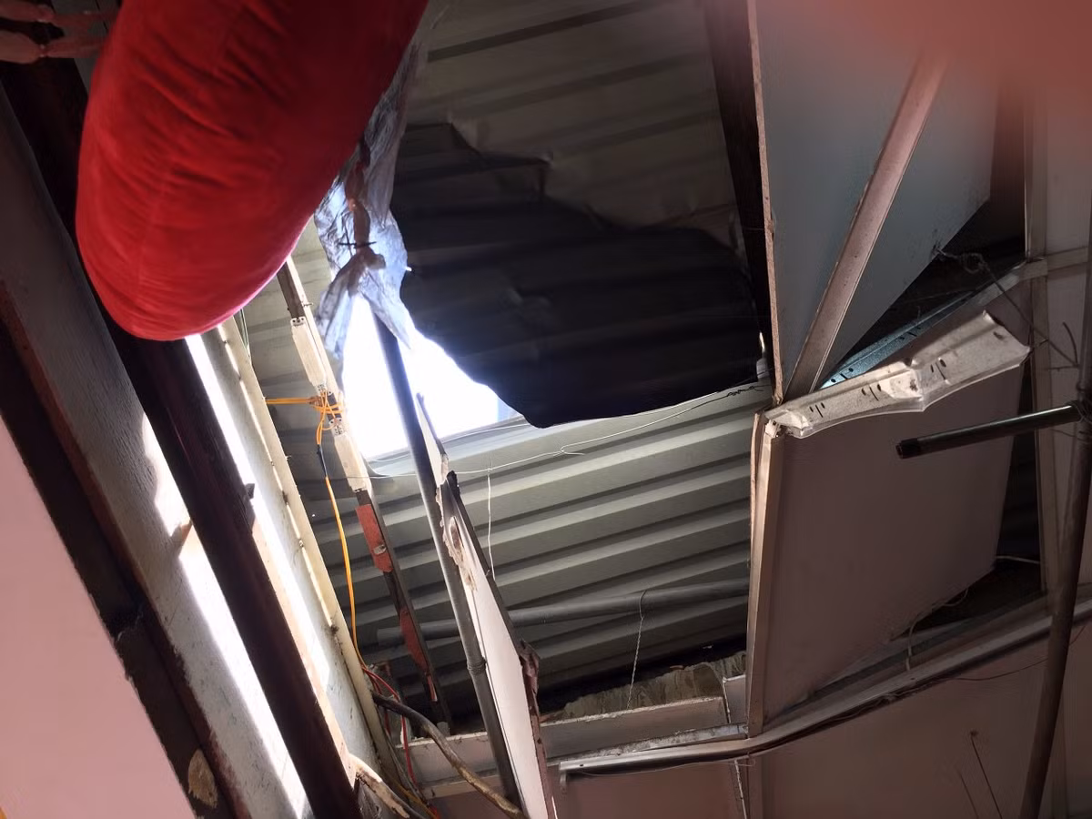 Tại hiện trường, 1 cột gỗ dùng để ép bê tông dài khoảng 5m đâm xuyên nóc nhà làm bể kệ kính của hộ kinh doanh vali, túi xách địa chỉ số 66 Văn Cao, phường Phú Thọ Hòa, quận Tân Phú, TP HCM.