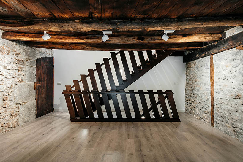 Cầu thang gỗ mộc mạc được thiết kế sát tường để tiết kiệm diện tích.