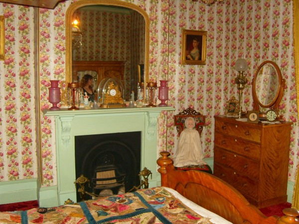 Phòng ngủ bày khá nhiều đồ đạc với gam màu nóng chủ đạo.