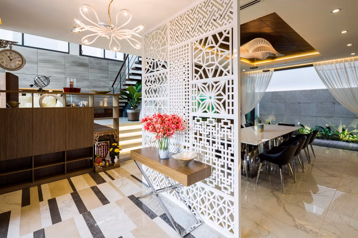 Giữa phòng bếp và phòng khách là phòng ăn với bức bình phong gỗ màu trắng và bàn console đóng vai trò vách ngăn.