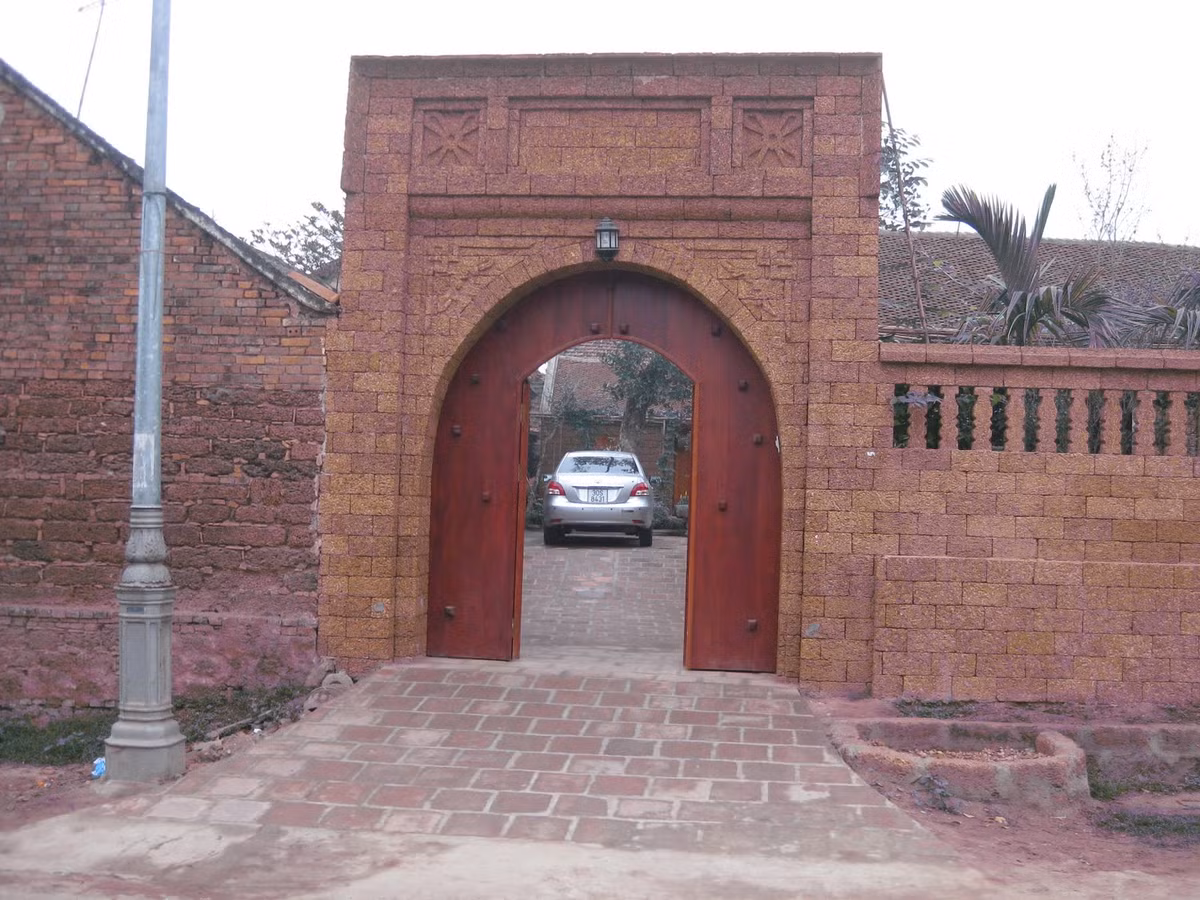 Cổng nhà bằng đá ong vàng rực mang đến vẻ đẹp tinh tế. Ảnh: Nhagomaket.